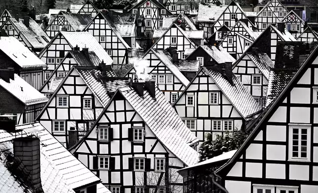 Snow falls on the roofs of the half-timbered houses in the historic city center in Freudenberg, Germany, Friday, Jan. 3, 2025 . (Federico Gambarini/dpa via AP)