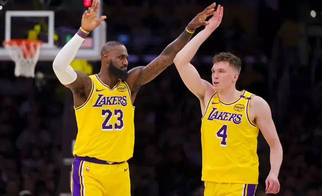 Los Angeles Lakers forward LeBron James (23) high-fives guard Dalton Knecht (4) during the first half of an NBA basketball game against the Cleveland Cavaliers, Tuesday, Dec. 31, 2024, in Los Angeles. (AP Photo/Ryan Sun)
