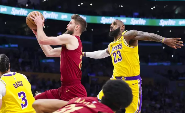 Cleveland Cavaliers forward Dean Wade, top left, drives past Los Angeles Lakers forward LeBron James (23) during the first half of an NBA basketball game Tuesday, Dec. 31, 2024, in Los Angeles. (AP Photo/Ryan Sun)