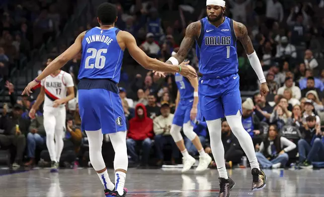 Dallas Mavericks' Spencer Dinwiddie (26) celebrates a three-pointer by Jaden Hardy (1) against the Portland Trail Blazers in the first half of an NBA basketball game, Thursday, Jan. 9, 2025, in Dallas. (AP Photo/Richard W. Rodriguez)