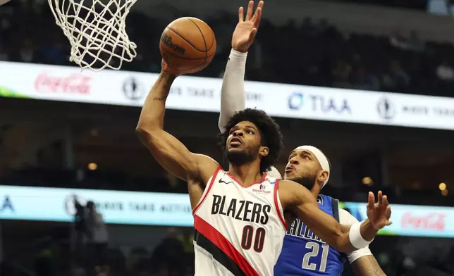 Portland Trail Blazers guard Scoot Henderson (00) shots against Dallas Mavericks' Daniel Gafford (21) in the first half of an NBA basketball game Thursday, Jan. 9, 2025, in Dallas. (AP Photo/Richard W. Rodriguez)