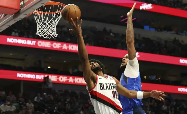 Portland Trail Blazers guard Scoot Henderson (00) shoots as Dallas Mavericks' Daniel Gafford (21) defends in an NBA basketball game Thursday, Jan. 9, 2025, in Dallas. (AP Photo/Richard W. Rodriguez)