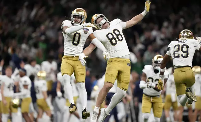 FILE - Notre Dame safety Xavier Watts (0) celebrates with teammate Armel Mukam (88) during the second half against Georgia in the quarterfinals of a College Football Playoff, Thursday, Jan. 2, 2025, in New Orleans. (AP Photo/Gerald Herbert, File)