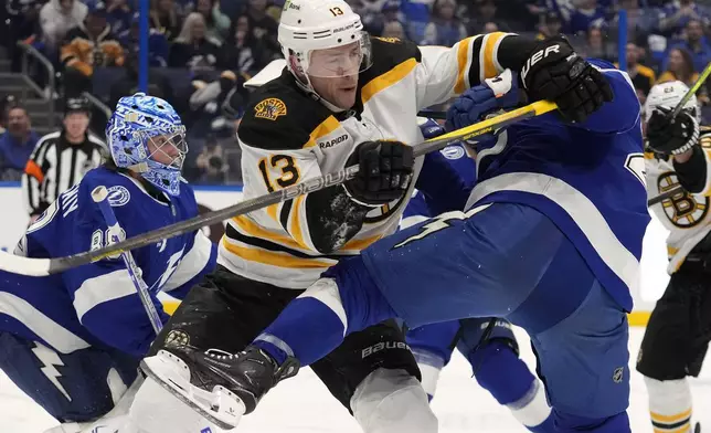 Boston Bruins center Charlie Coyle (13) battles with Tampa Bay Lightning right wing Mitchell Chaffee during the third period of an NHL hockey game Thursday, Jan. 9, 2025, in Tampa, Fla. (AP Photo/Chris O'Meara)