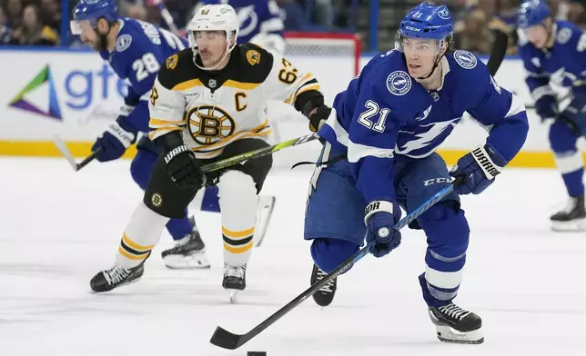 Tampa Bay Lightning center Brayden Point (21) breaks out ahead of Boston Bruins left wing Brad Marchand (63) during the second period of an NHL hockey game Thursday, Jan. 9, 2025, in Tampa, Fla. (AP Photo/Chris O'Meara)