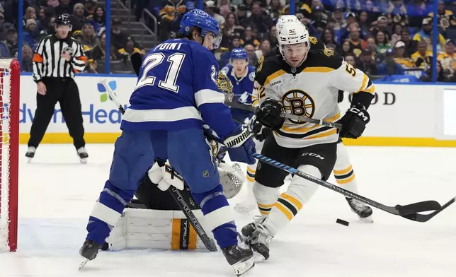 Boston Bruins defenseman Andrew Peeke (52) blocks a shot by Tampa Bay Lightning center Brayden Point (21) during the second period of an NHL hockey game Thursday, Jan. 9, 2025, in Tampa, Fla. (AP Photo/Chris O'Meara)