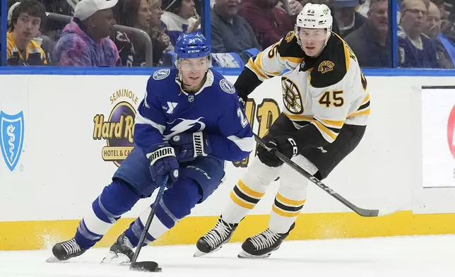 Tampa Bay Lightning center Brayden Point (21) works around Boston Bruins left wing Cole Koepke (45) during the first period of an NHL hockey game Thursday, Jan. 9, 2025, in Tampa, Fla. (AP Photo/Chris O'Meara)