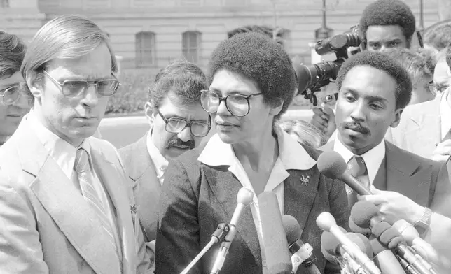 FILE - Anita DeFrantz, spokeswoman for the U.S. Olympic Committee's Athletes Advisory Council, flanked by Larry Hough, left, and Fred Newhouse right, answers questions from reporters outside the White House in Washington on April 4, 1980, after White House officials rejected a proposal that would have allowed American athletes to compete at the summer Olympic Games in Moscow. (AP Photo, File)