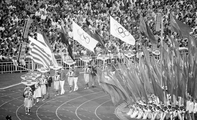 FILE - Flag and sign bearers march around Moscow's Lenin Stadium during closing ceremonies of the XXII Summer Olympic Games in Moscow, on Aug. 3, 1980. (AP Photo/File)