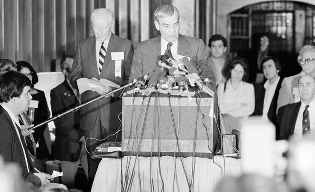 FILE - F. Don Miller, executive director of the U.S. Olympic Committee, reads a resolution adopted by the U.S. Olympic Committee's House of Delegates to boycott the 1980 Summer Games in Moscow, in Colorado Springs, Colo., April 12, 1980. At left is Robert Kane, president of the U.S. Olympic Committee. (AP Photo/Ed Andrieski, File)