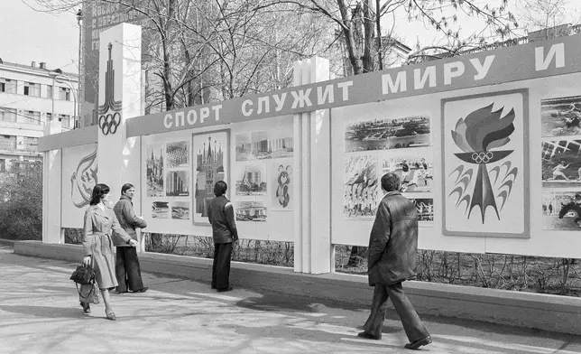 FILE - Passersby examine the new Olympic billboard reading, "Sport Serves Peace," erected after the United States announced it was boycotting the games in Moscow on April 23, 1980. (AP Photo/Yurchenko, File)