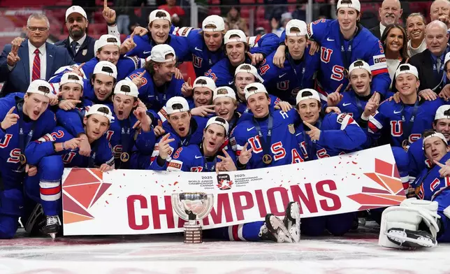 United States players pose for a group photo with the trophy following the IIHF World Junior Hockey Championship gold medal game win over Finland, in Ottawa, Ontario, Sunday, Jan. 5, 2025. (Sean Kilpatrick/The Canadian Press via AP)