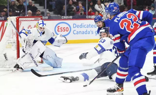 Finland defenseman Aron Kiviharju (33) blocks a shot against teammate Petteri Rimpinen (30) as United States forward Brandon Svoboda (8) and Max Plante (22) rush the net during third -period IIHF World Junior Hockey Championship gold medal game action in Ottawa, Ontario, Sunday, Jan. 5, 2025. (Sean Kilpatrick/The Canadian Press via AP)