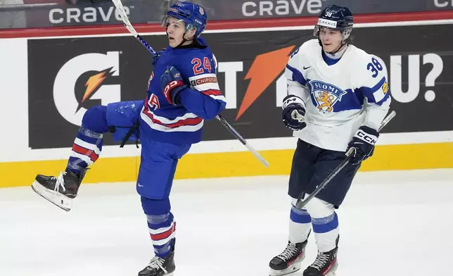 United States defenseman Cole Hutson (24) celebrates after his goal as he skates past Finland forward Jesse Kiiskinen (38) during second-period IIHF World Junior Hockey Championship gold medal game action in Ottawa, Ontario, Sunday, Jan. 5, 2025. (Adrian Wyld/The Canadian Press via AP)