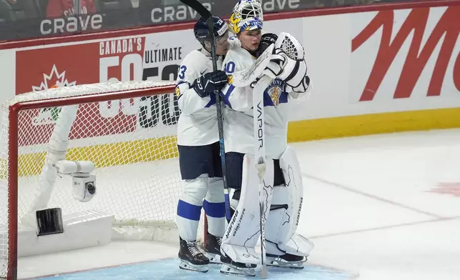 Finland defenseman Aron Kiviharju (33) consoles Finland goaltender Petteri Rimpinen (30) following their overtime loss to the United States in the IIHF World Junior Hockey Championship gold medal game in Ottawa, Ontario, Sunday, Jan. 5, 2025. (Adrian Wyld/The Canadian Press via AP)