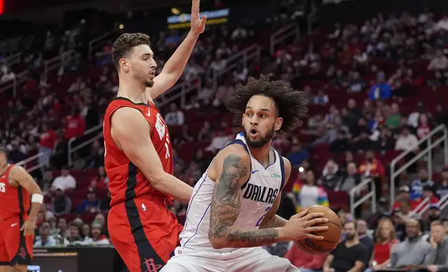 Dallas Mavericks' Dereck Lively II (2) looks to shoot as Houston Rockets' Alperen Sengun defends during the first half of an NBA basketball game Wednesday, Jan. 1, 2025, in Houston. (AP Photo/David J. Phillip)