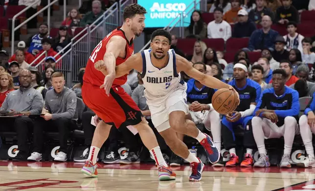 Dallas Mavericks' Quentin Grimes (5) is fouled by Houston Rockets' Alperen Sengun (28) during the first half of an NBA basketball game Wednesday, Jan. 1, 2025, in Houston. (AP Photo/David J. Phillip)