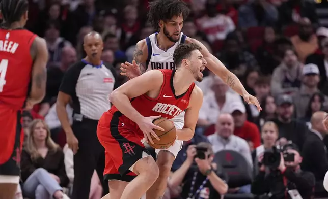 Houston Rockets' Alperen Sengun, bottom, is fouled by Dallas Mavericks' Dereck Lively II during the first half of an NBA basketball game Wednesday, Jan. 1, 2025, in Houston. (AP Photo/David J. Phillip)