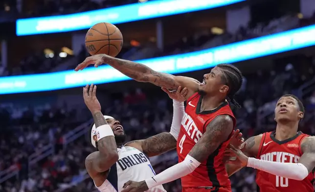 Dallas Mavericks' Jaden Hardy (1) has his shot blocked by Houston Rockets' Jalen Green (4) during the first half of an NBA basketball game Wednesday, Jan. 1, 2025, in Houston. (AP Photo/David J. Phillip)