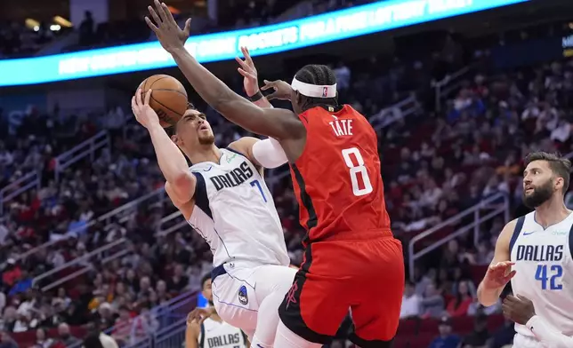 Dallas Mavericks' Dwight Powell (7) is fouled by Houston Rockets' Jae'Sean Tate (8) during the first half of an NBA basketball game Wednesday, Jan. 1, 2025, in Houston. (AP Photo/David J. Phillip)