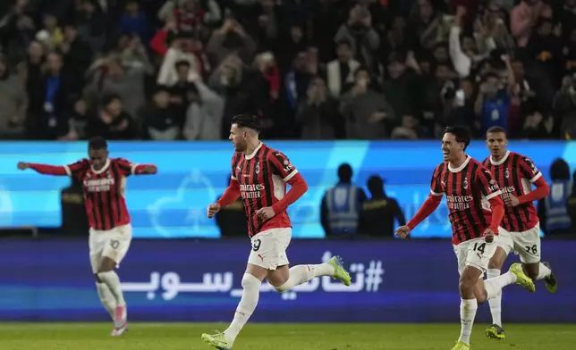 AC Milan's Theo Hernandez, center, celebrates with teammates after scoring his sides first goal during the Italian Super Cup final soccer match between AC Milan and Inter Milan at Al Awwal Park Stadium in Riyadh, Saudi Arabia, Monday, Jan. 6, 2025. (AP Photo/Altaf Qadri)