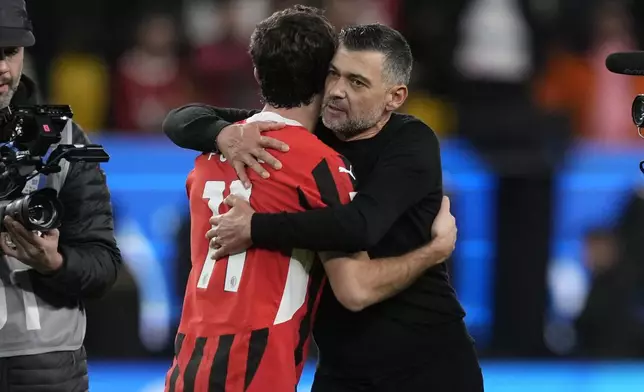 AC Milan's head coach Sergio Conceicao hugs Christian Pulisic after the Italian Super Cup semifinal soccer match between Juventus and Milan in Riyadh, Saudi Arabia, Friday, Jan. 3, 2025. (AP Photo/Altaf Qadri)