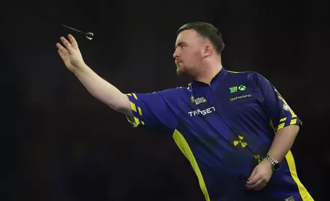 Luke Littler of England throws his dart during the semifinal match against Stephen Bunting of England, at the World Darts Championship in London, Thursday, Jan. 2, 2025. (AP Photo/Kirsty Wigglesworth)