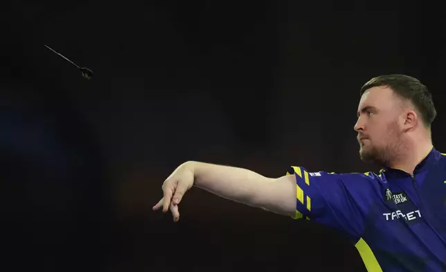 Luke Littler of England throws his dart during the semifinal match against Stephen Bunting of England, at the World Darts Championship in London, Thursday, Jan. 2, 2025. (AP Photo/Kirsty Wigglesworth)