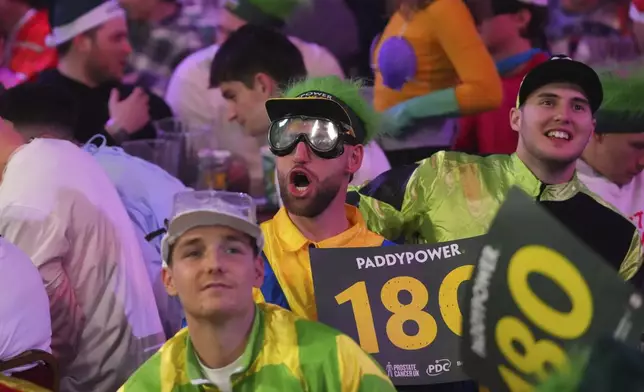 Fans dressed in costumes are seen during the semifinal match between Michael van Gerwen of the Netherlands and Chris Dobey of England, at the World Darts Championship in London, Thursday, Jan. 2, 2025. (AP Photo/Kirsty Wigglesworth)