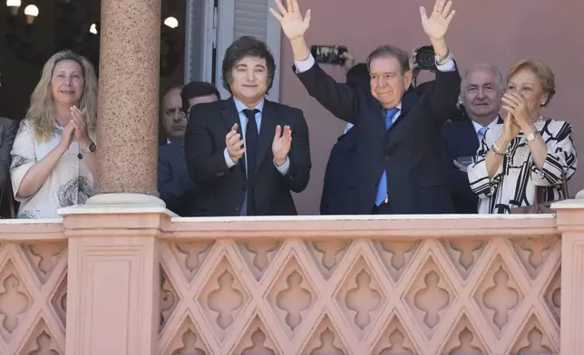 Venezuela's opposition leader Edmundo Gonzalez Urrutia, center right, and Argentine President Javier Milei wave to supporters from the government house in Buenos Aires, Argentina, Saturday, Jan. 4, 2025. Gonzalez, who claims he won the 2024 presidential election and is recognized by some countries as the legitimate president-elect, traveled from exile in Madrid to Argentina. (AP Photo/Natacha Pisarenko)