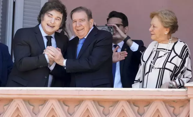 Venezuela's opposition leader Edmundo Gonzalez Urrutia, center, his wife Mercedes Lopez, right, and Argentine President Javier Milei stand at the balcony of the government house in Buenos Aires, Argentina, Saturday, Jan. 4, 2025. Gonzalez, who claims he won the 2024 presidential election and is recognized by some countries as the legitimate president-elect, traveled from exile in Madrid to Argentina. (AP Photo/Natacha Pisarenko)