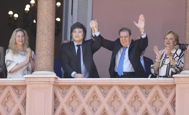 Venezuela's opposition leader Edmundo Gonzalez Urrutia, center right, and Argentine President Javier Milei hold hands from the government house balcony in Buenos Aires, Argentina, Saturday, Jan. 4, 2025. Gonzalez, who claims he won the 2024 presidential election and is recognized by some countries as the legitimate president-elect, traveled from exile in Madrid to Argentina. (AP Photo/Natacha Pisarenko)