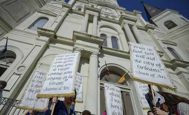 The Krewe de Jeanne d'Arc gather in front of St. Louis Cathedral in New Orleans, Sunday, Jan. 5, 2025, after a mass where Father Patrick Williams spoke of the victims of the New Year's Day deadly truck attack and shooting on Bourbon Street not far from the cathedral in the French Quarter. (AP Photo/Matthew Hinton)
