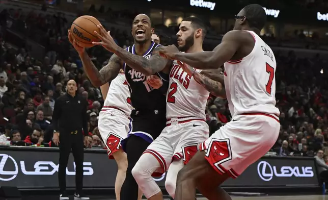 Sacramento Kings' DeMar DeRozan, third from right, goes up to shoot against Chicago Bulls' Lonzo Ball (2), Jalen Smith (7) and Josh Giddy, front left, during the first half of an NBA basketball game on Sunday, Jan. 12, 2025, in Chicago. (AP Photo/Paul Beaty)