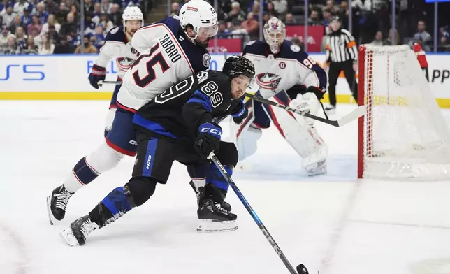 Toronto Maple Leafs' Nicholas Robertson (89) protects the puck from Columbus Blue Jackets' Dante Fabbro during the second period of an NHL hockey game in Toronto on Wednesday, Jan. 22, 2025. (Frank Gunn/The Canadian Press via AP)