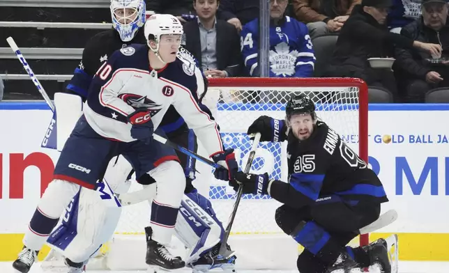 Toronto Maple Leafs goaltender Dennis Hildeby, Columbus Blue Jackets' Dmitri Voronkov (10) and Maple Leafs' Oliver Ekman-Larsson (95) look for the puck during the second period of an NHL hockey game in Toronto on Wednesday, Jan. 22, 2025. (Frank Gunn/The Canadian Press via AP)
