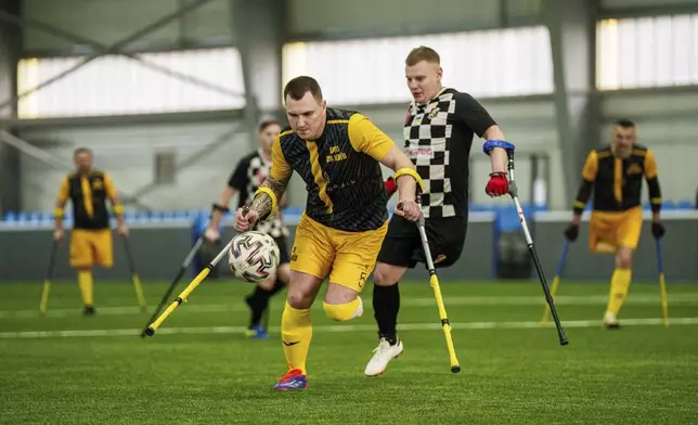 Soccer players of AMP FC Kyiv and MSK Dnipro play during the first football tournament for war-wounded amputees in Kyiv, Ukraine, Jan. 12, 2025. (AP Photo/Evgeniy Maloletka)