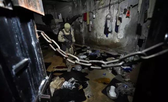 A member of the security forces for the new interim Syrian government inspects a cell of the Palestine Branch detention facility operated during Bashar Assad's regime, in Damascus, Syria, on Dec. 14, 2024. (AP Photo/Hussein Malla)