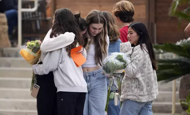 Mourners embrace before a memorial service at First Christian Church in Huntington Beach, Calif., Friday, Jan. 3, 2025, for those killed in a small plane crash the day before. (AP Photo/Damian Dovarganes)