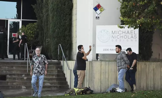 People stand outside of a building where a plane crash occurred Thursday, Jan. 2, 2025, in Fullerton, Calif. (AP Photo/Kyusung Gong)