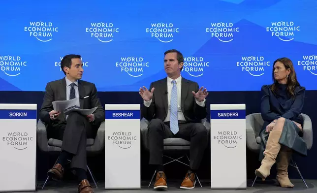 Kentucky Governor Andy Beshear, center, gestures besides Arkansas Gov. Sarah Huckabee Sanders at the Annual Meeting of World Economic Forum in Davos, Switzerland, Thursday, Jan. 23, 2025. (AP Photo/Markus Schreiber)