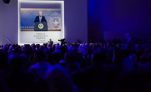 Attendees listen to a virtual speech delivered by U.S. president Donald Trump, at the Annual Meeting of World Economic Forum in Davos, Switzerland, Thursday, Jan. 23, 2025. (AP Photo/Markus Schreiber)
