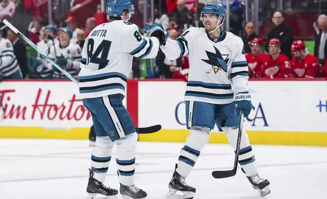 San Jose Sharks defenseman Cody Ceci (4) and San Jose Sharks defenseman Jan Rutta (84) celebrate after a goal to go up in the first period of an NHL hockey game against the Detroit Red Wings Tuesday, Jan. 14, 2025, in Detroit. (AP Photo/Mike Mulholland)