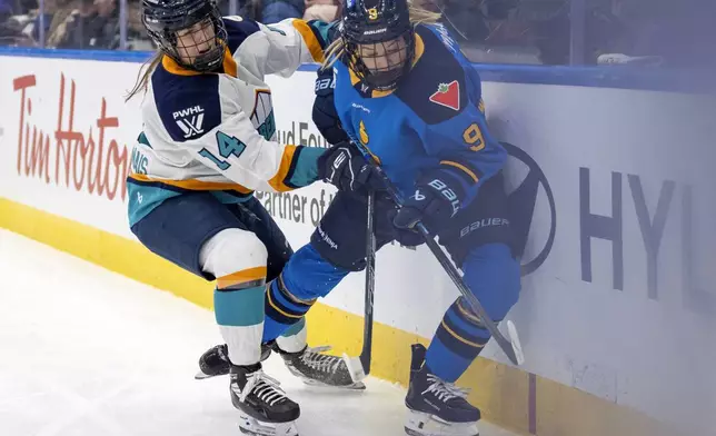 New York Sirens defender Jaime Bourbonnais (14) checks Toronto Sceptres forward Daryl Watts (9) along the boards during the first period of a PWHL hockey game in Toronto, Saturday Jan. 25, 2025. (Frank Gunn/The Canadian Press via AP)