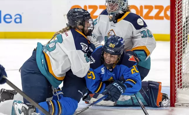 New York Sirens defenseman Allyson Simpson (20) takes Toronto Sceptres forward Sarah Nurse (20) to the ice in front of Sirens goaltender Corinne Schroeder (30) during the first period of a PWHL hockey game in Toronto, Saturday Jan. 25, 2025. (Frank Gunn/The Canadian Press via AP)