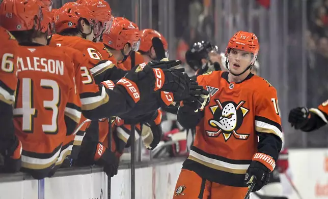 Anaheim Ducks right wing Troy Terry is congratulated at the bench after scoring a goal during the first period of an NHL hockey against the New Jersey Devils, Tuesday, Dec. 31, 2024, in Anaheim, Calif. (AP Photo/Jayne-Kamin-Oncea)