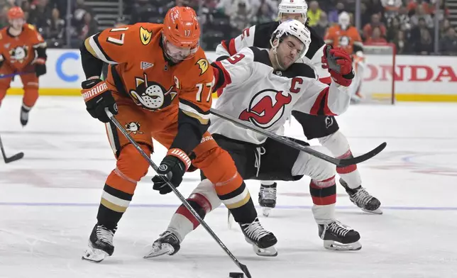 Anaheim Ducks left wing Alex Killorn, left, and New Jersey Devils center Nico Hischier battle for the puck during the second period of an NHL hockey game Tuesday, Dec. 31, 2024, in Anaheim, Calif. (AP Photo/Jayne Kamin-Oncea)