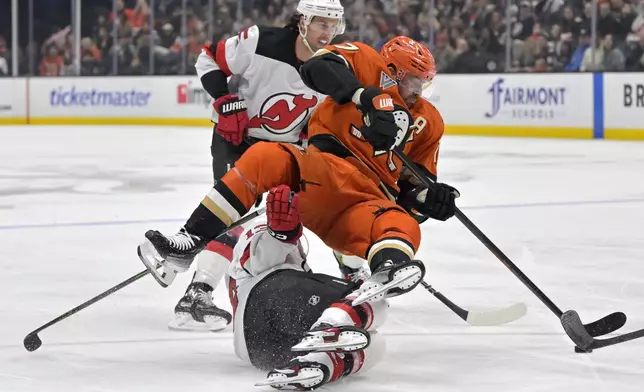 Anaheim Ducks left wing Alex Killorn, left, and New Jersey Devils center Nico Hischier battle for the puck during the second period of an NHL hockey game Tuesday, Dec. 31, 2024, in Anaheim, Calif. (AP Photo/Jayne Kamin-Oncea)