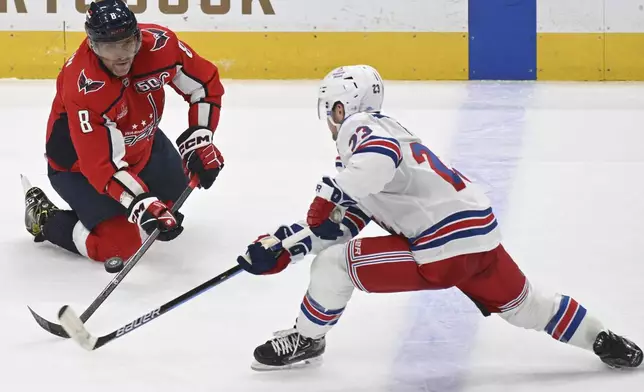 Washington Capitals left wing Alex Ovechkin (8) competes for the puck with New York Rangers defenseman Adam Fox during the third period of an NHL hockey game Saturday, Jan. 4, 2025, in Washington. (AP Photo/John McDonnell)