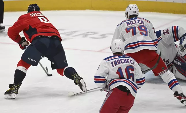 Washington Capitals left wing Alex Ovechkin, left, scores a goal during the third period of an NHL hockey game against the New York Rangers, Saturday, Jan. 4, 2025, in Washington. (AP Photo/John McDonnell)